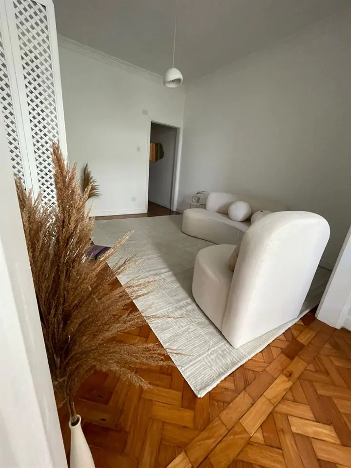 Sala de atendimento com sofá e poltrona claros