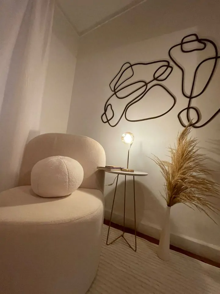 Poltrona com luminária acesa e arte na parede